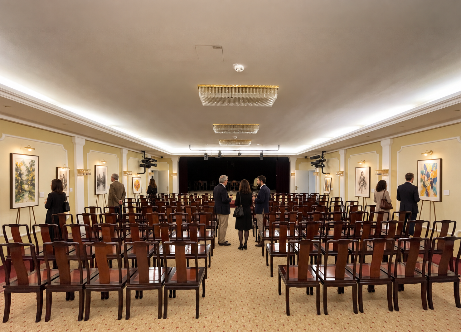 Besucher betrachten Bilder im Theatersaal
